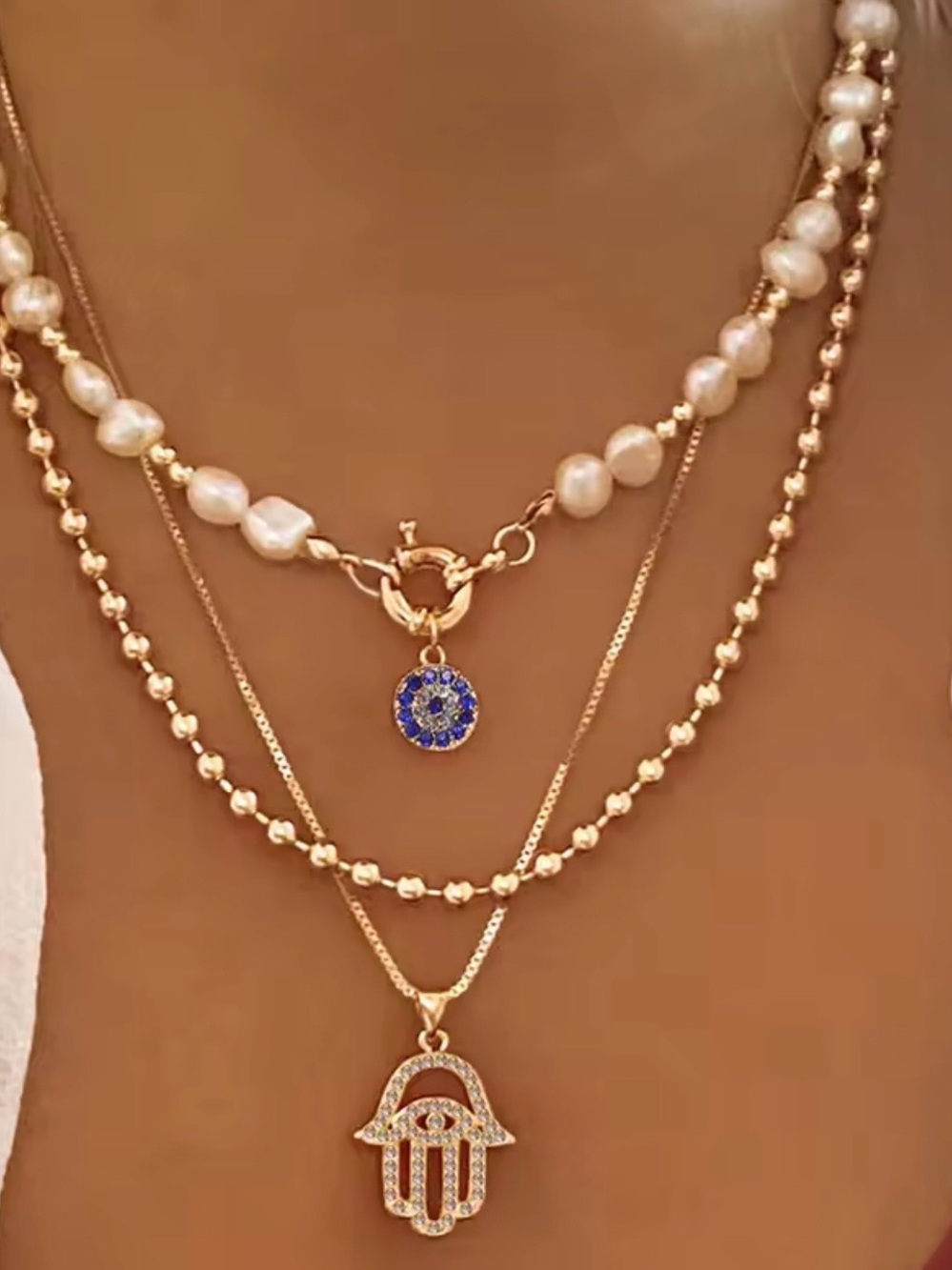 Multi-Layered Gold Pearl Hamsa Necklace with Blue Charm